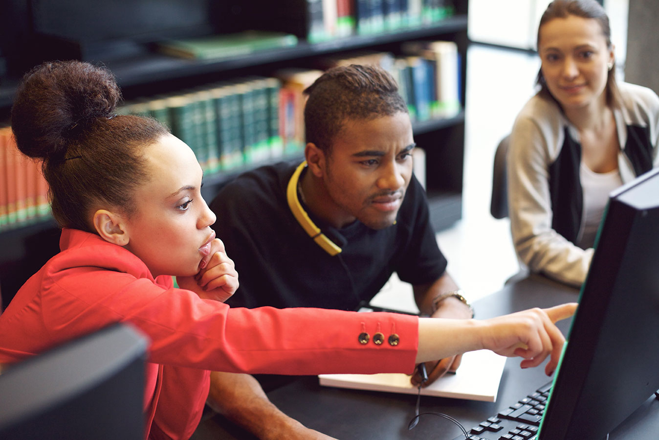 students-pointing-at-computer-in-library.jpg